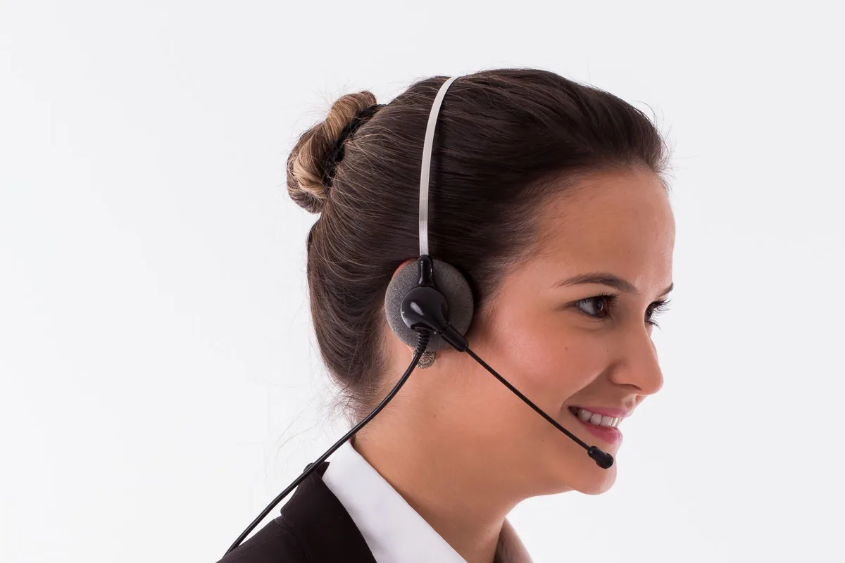 Customer service representative wearing a telephone headset while answering a call